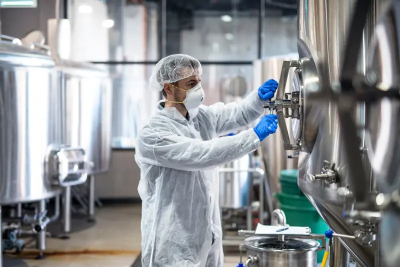 Technologist operating equipment in a sterile facility